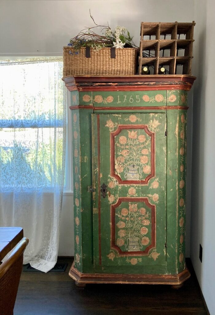 a green cabinet with a basket on top of it