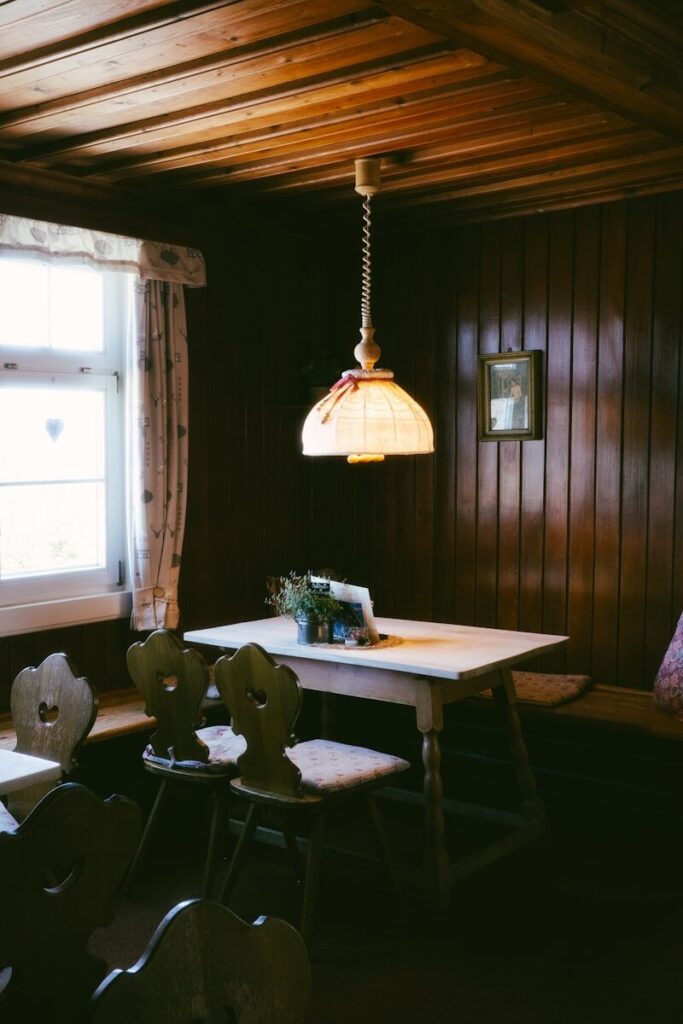 Cozy dining area with wooden walls and a table.
